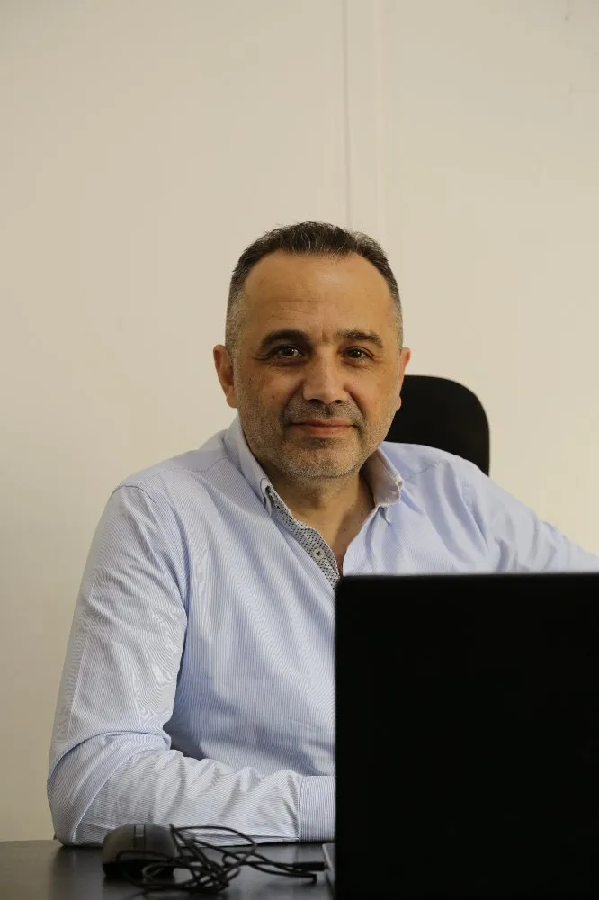 A man sitting at a desk with a laptop, focused on his work.